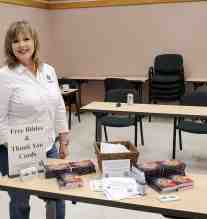 Diane Langan, Quality Control for Morale Boosters standing next to the bible and information table.