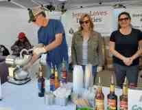 Morale Boosters volunteer Mike and Crystal Hagan serve Snow-Cones while ICE Agent Trish stands by. Thank You Banners hang in the background.