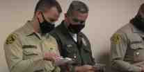 Two LA Sheriff Deputies reading hand written note cards sent by Morale Boosters