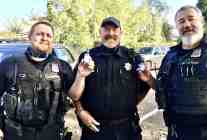 Three senior Portland Police Officers stand holding the special hand sanitizers Morale Boosters sent. along with many Thank You notes, and a signed banner to encourage them.